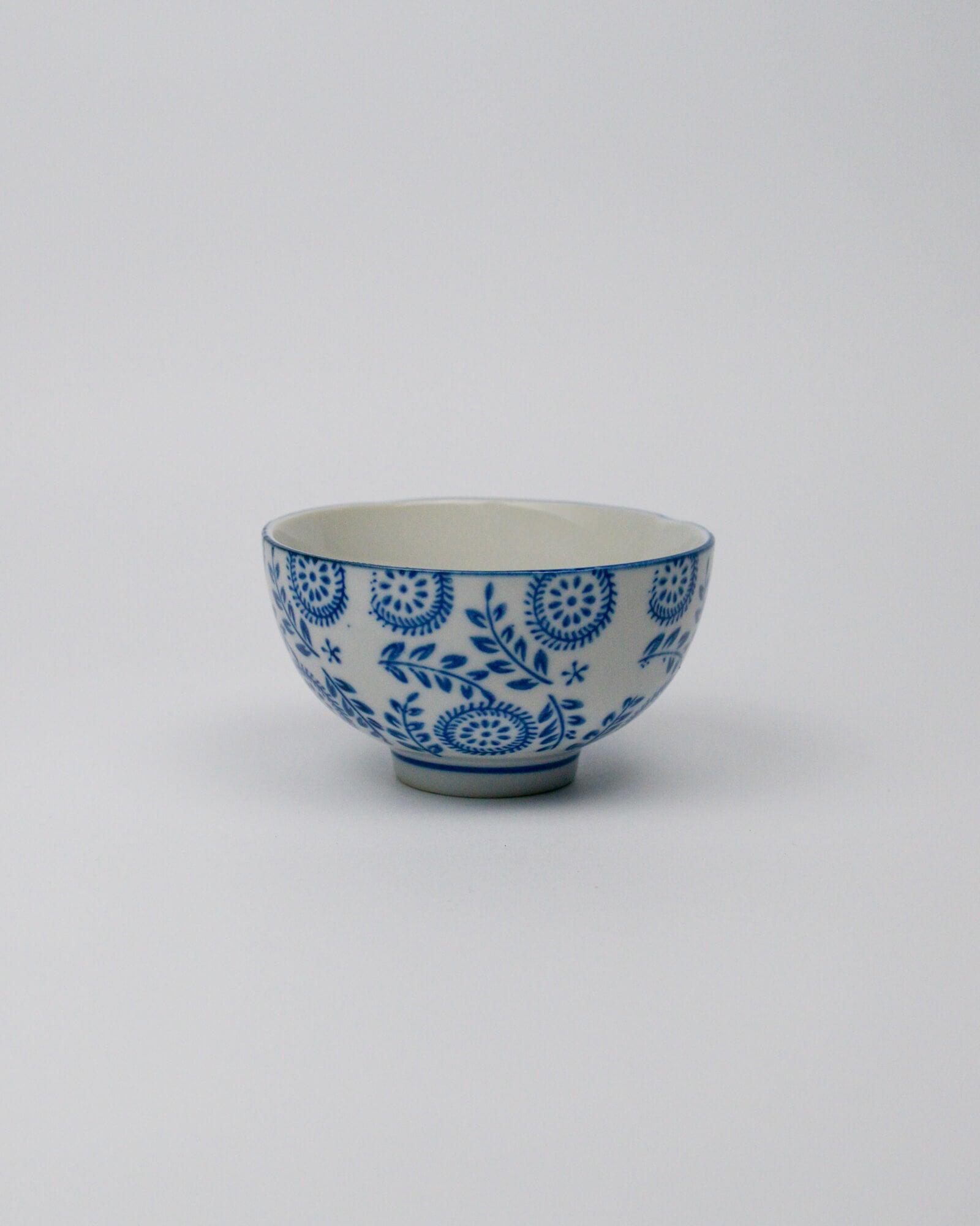Small ceramic bowl with blue floral patterns on a white background
