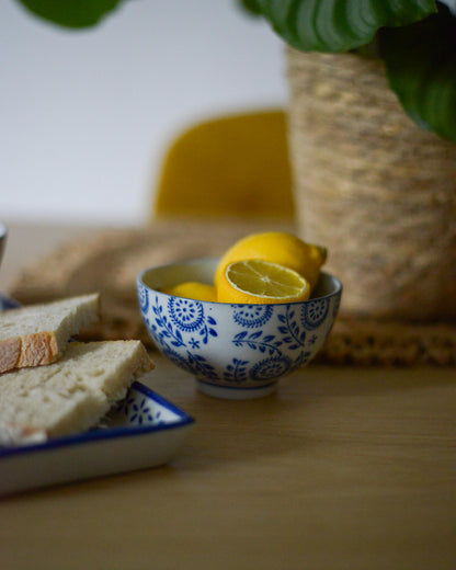 Small cermic bowl with lemons and bread slices on a wooden surface
