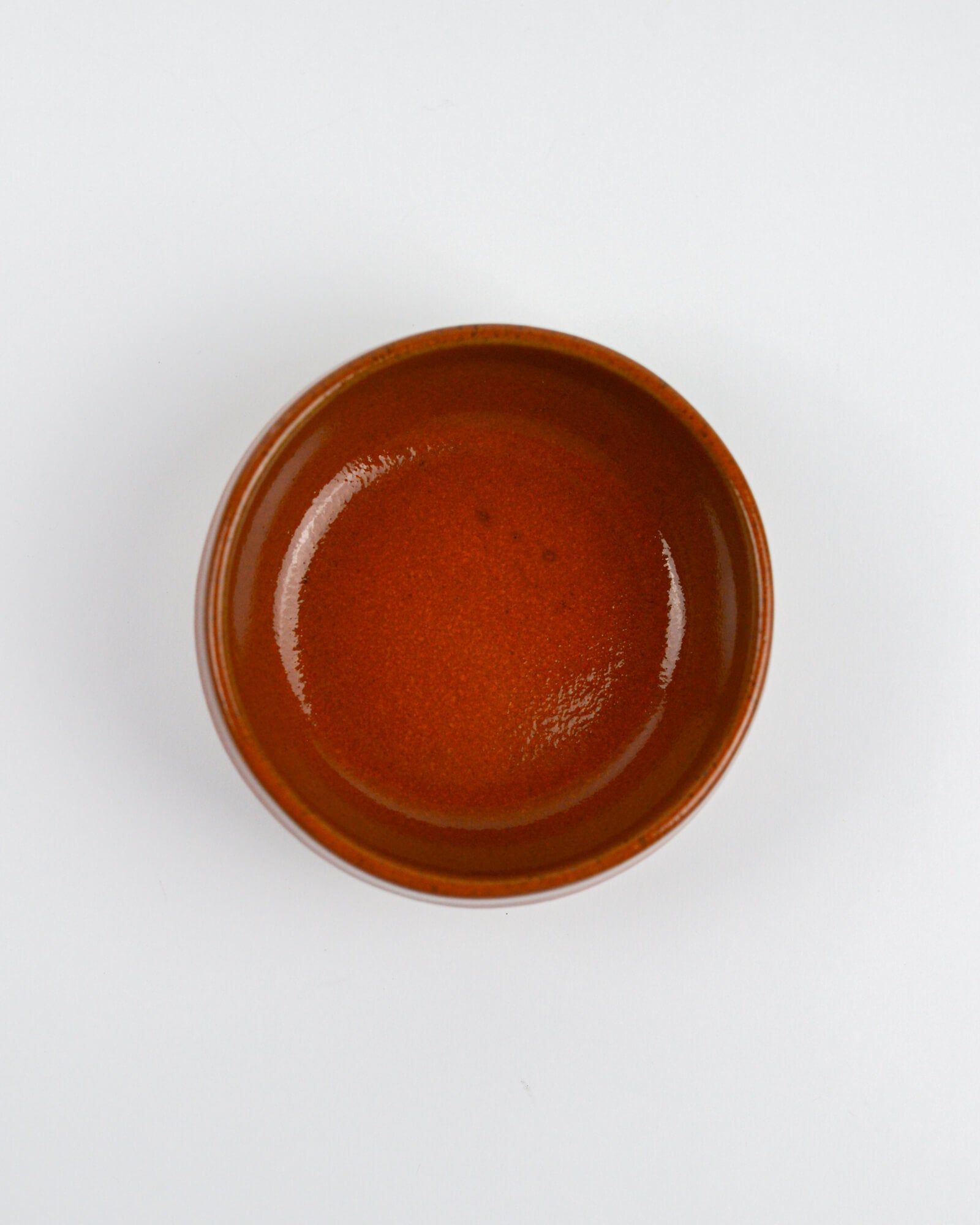 Cinnamon coloured stoneware ceramic dipping bowl on a white background
