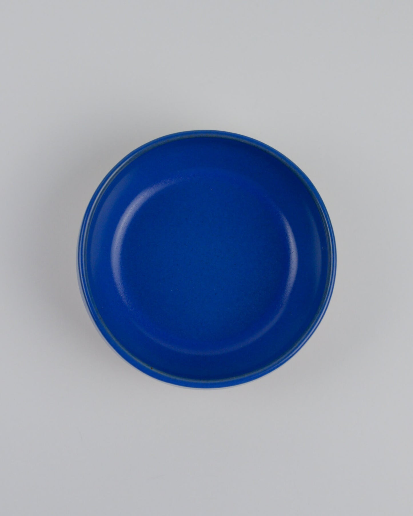 Blue ceramic dipping bowl on a white background