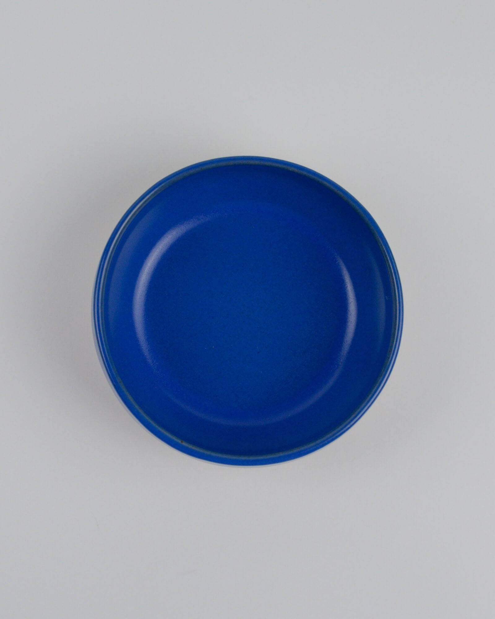 Blue ceramic dipping bowl on a white background