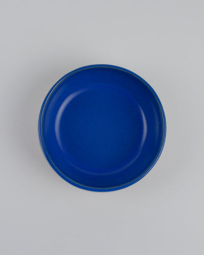 Blue ceramic dipping bowl on a white background