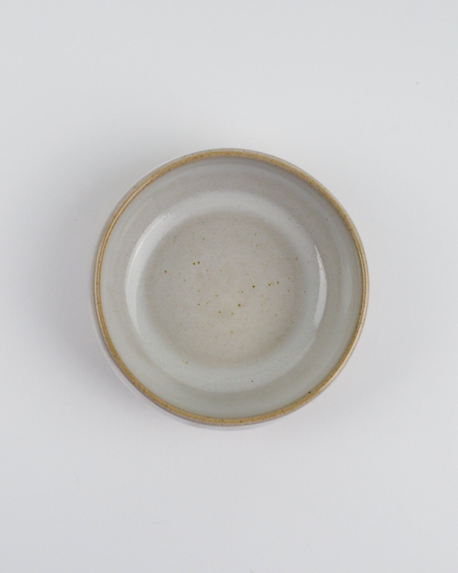 Ceramic dipping bowl with a textured rim on a white background