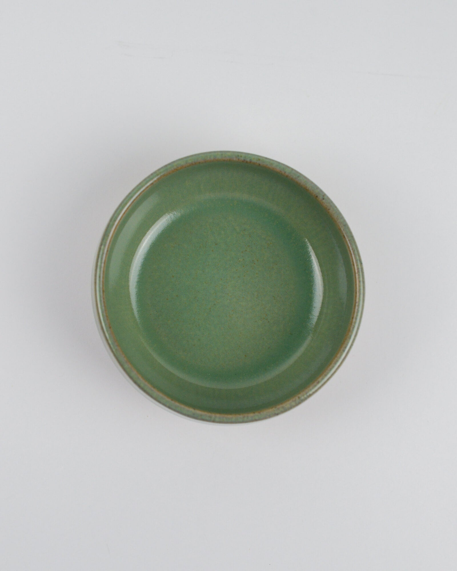 Green ceramic dipping bowl on a white background