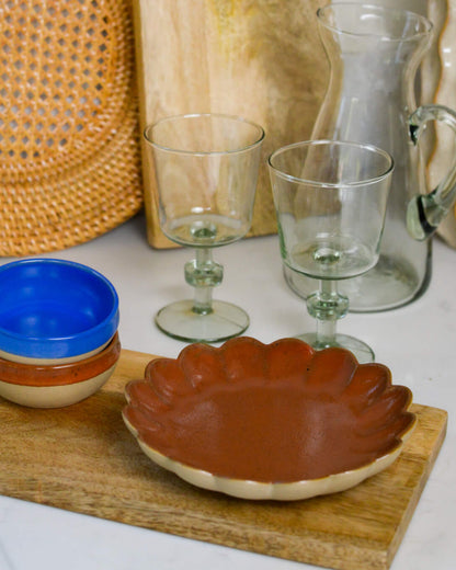 Ceramic stoneware dipping bowls and a stoneware scalloped edge appetiser plate 
on a wooden surface