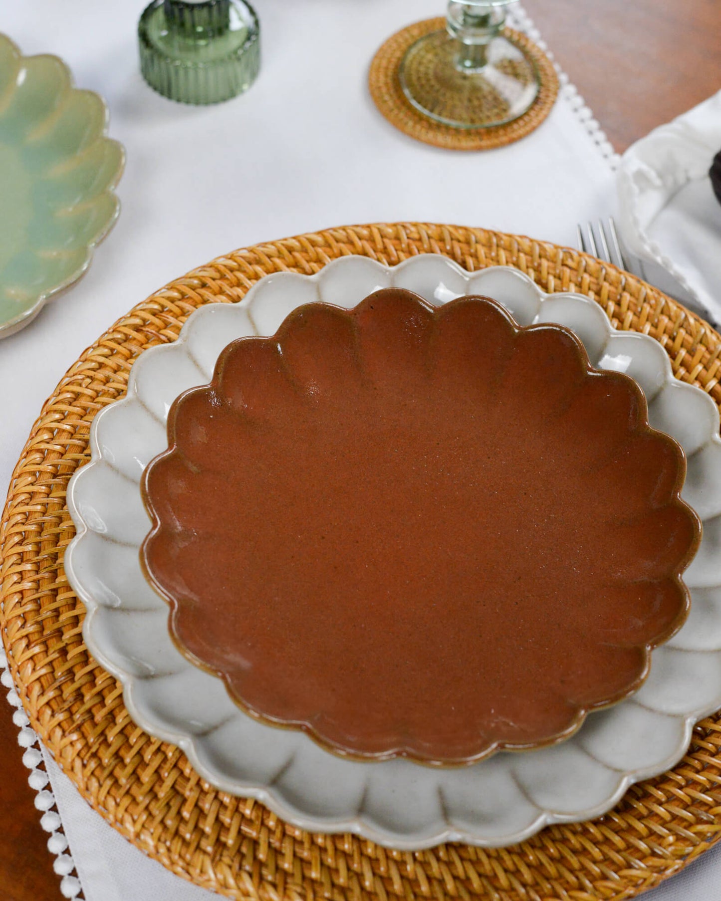 Ceramic plate with scalloped edge on a woven rattan charger plate