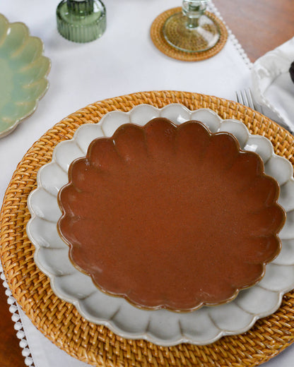 Ceramic plate with scalloped edge on a woven rattan charger plate