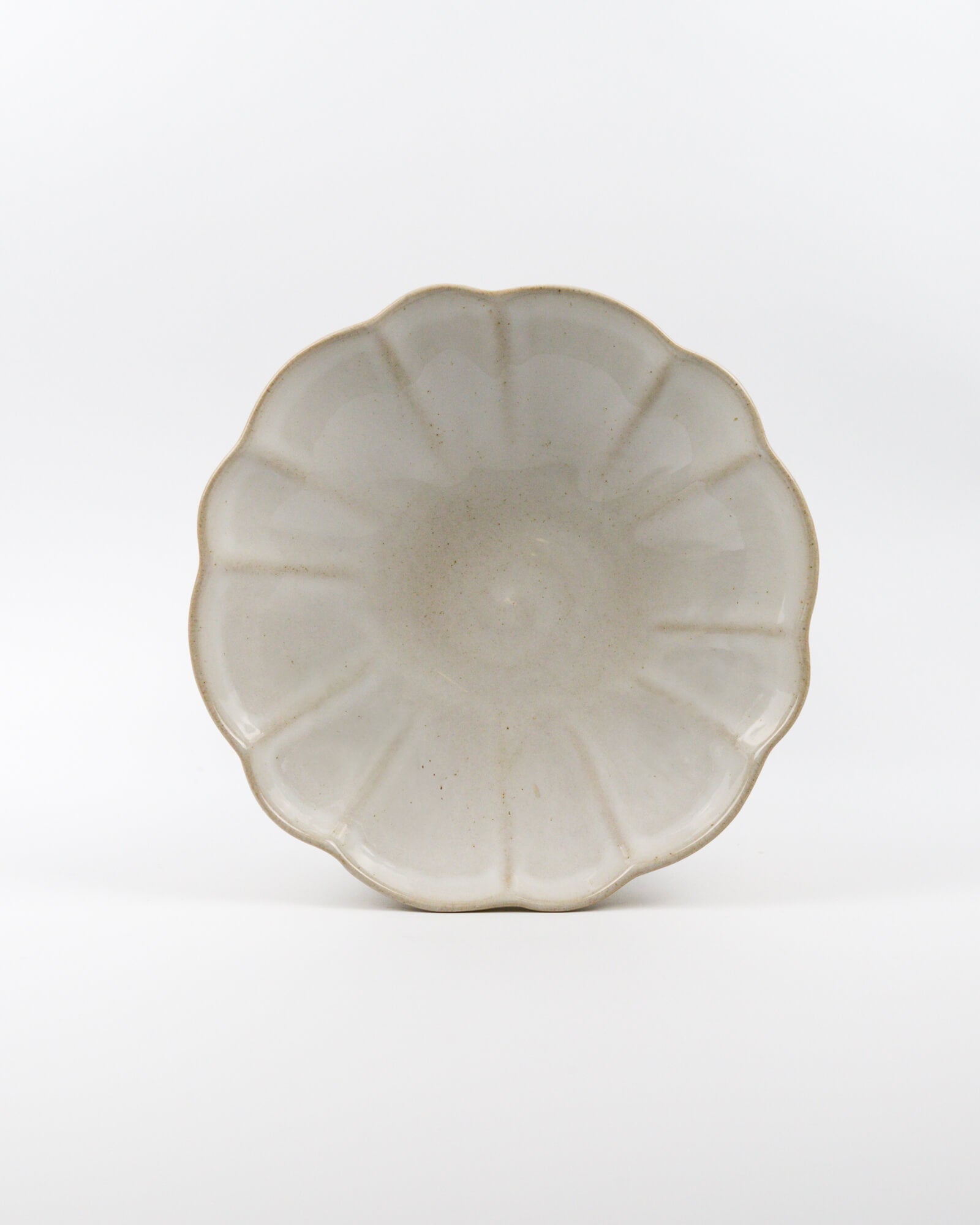 Ceramic stoneware scalloped edge pasta bowl with a textured surface on a white background