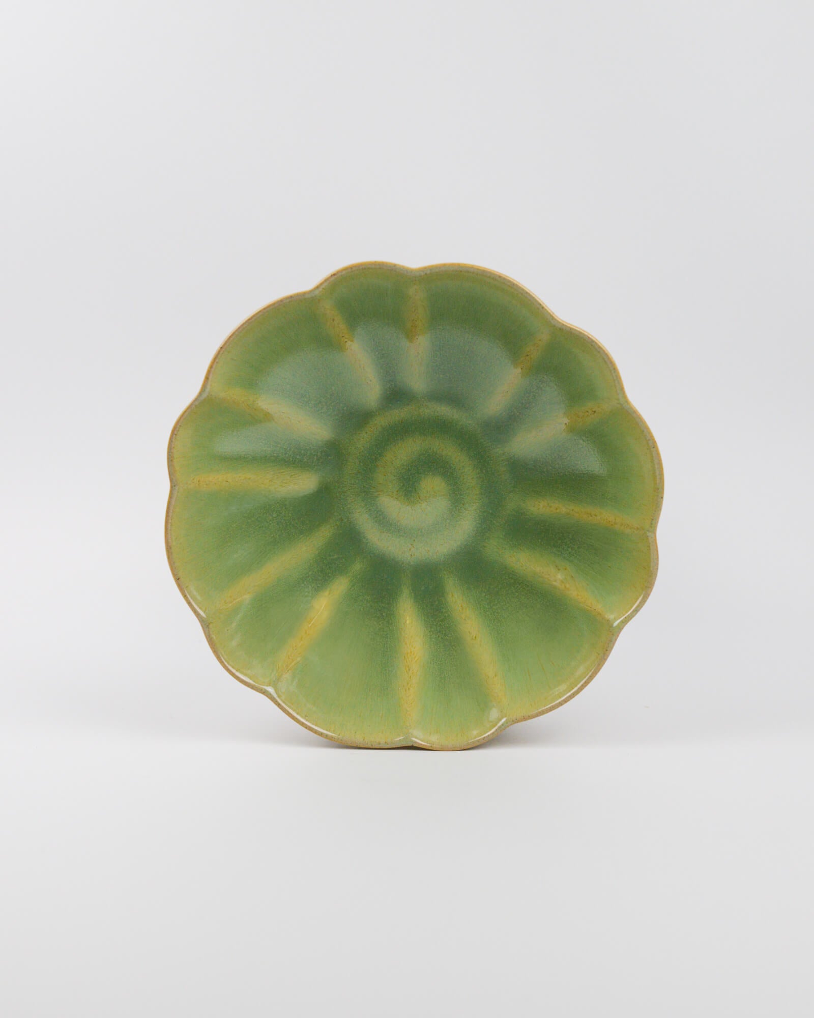 Green ceramic stoneware pasta dish on a white background