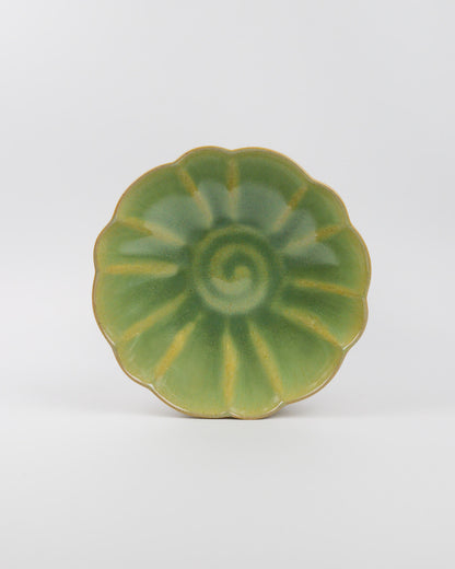 Green ceramic stoneware pasta dish on a white background