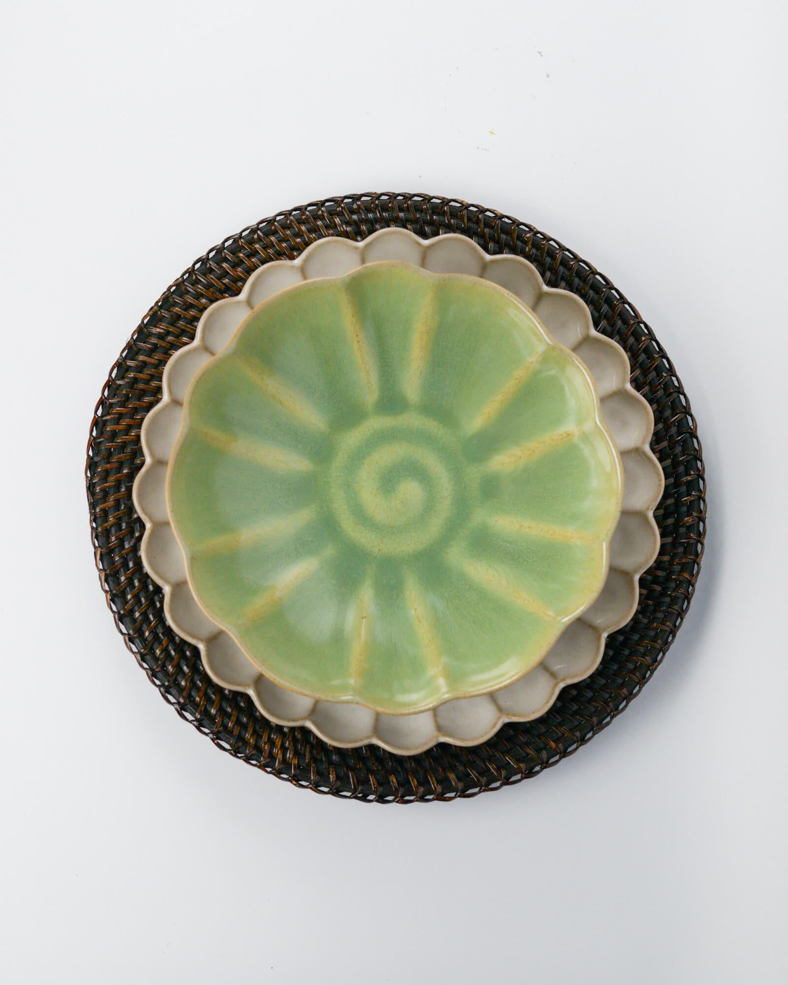 Ceramic stoneware pasta plate with green spiral design on a white background