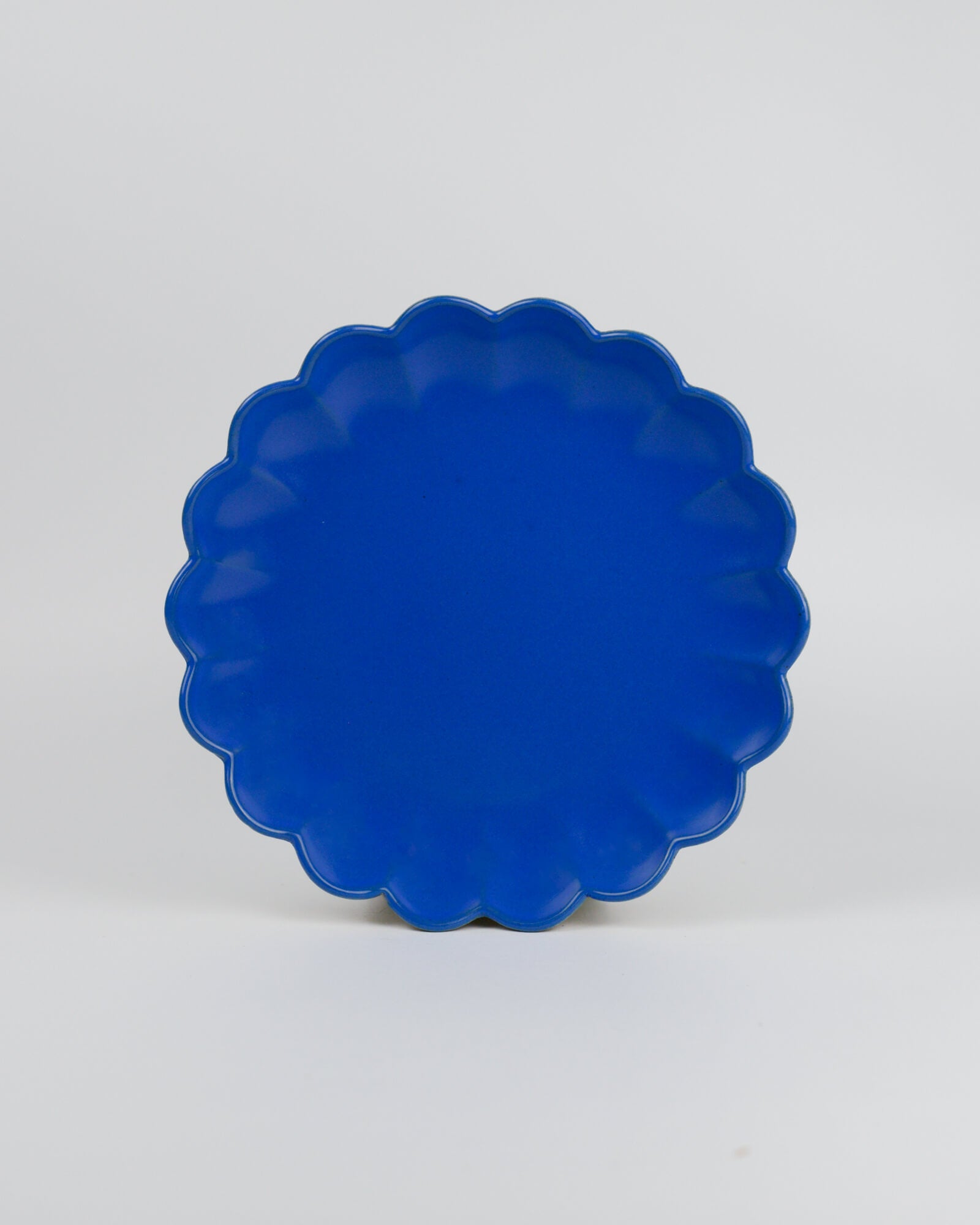 Blue scalloped-edge dish on a white background