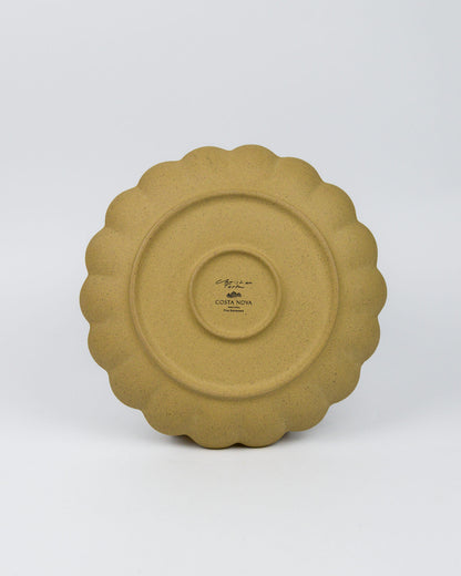 Ceramic stoneware plate with scalloped edge on a white background