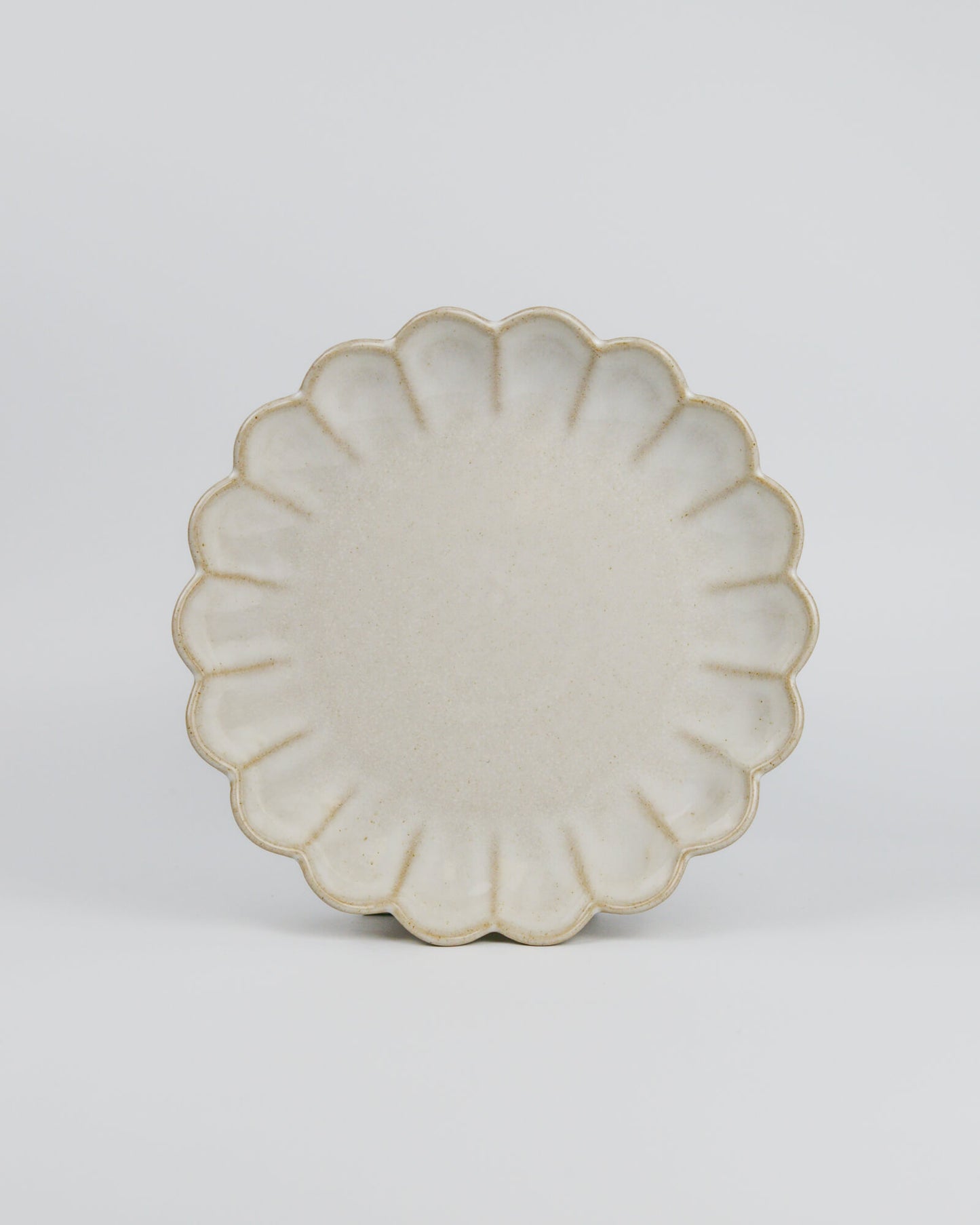 Decorative ceramic dessert plate with a floral scalloped edge on a white background