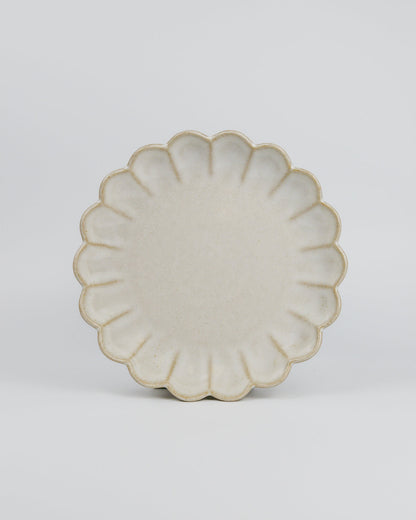 Decorative ceramic dessert plate with a floral scalloped edge on a white background
