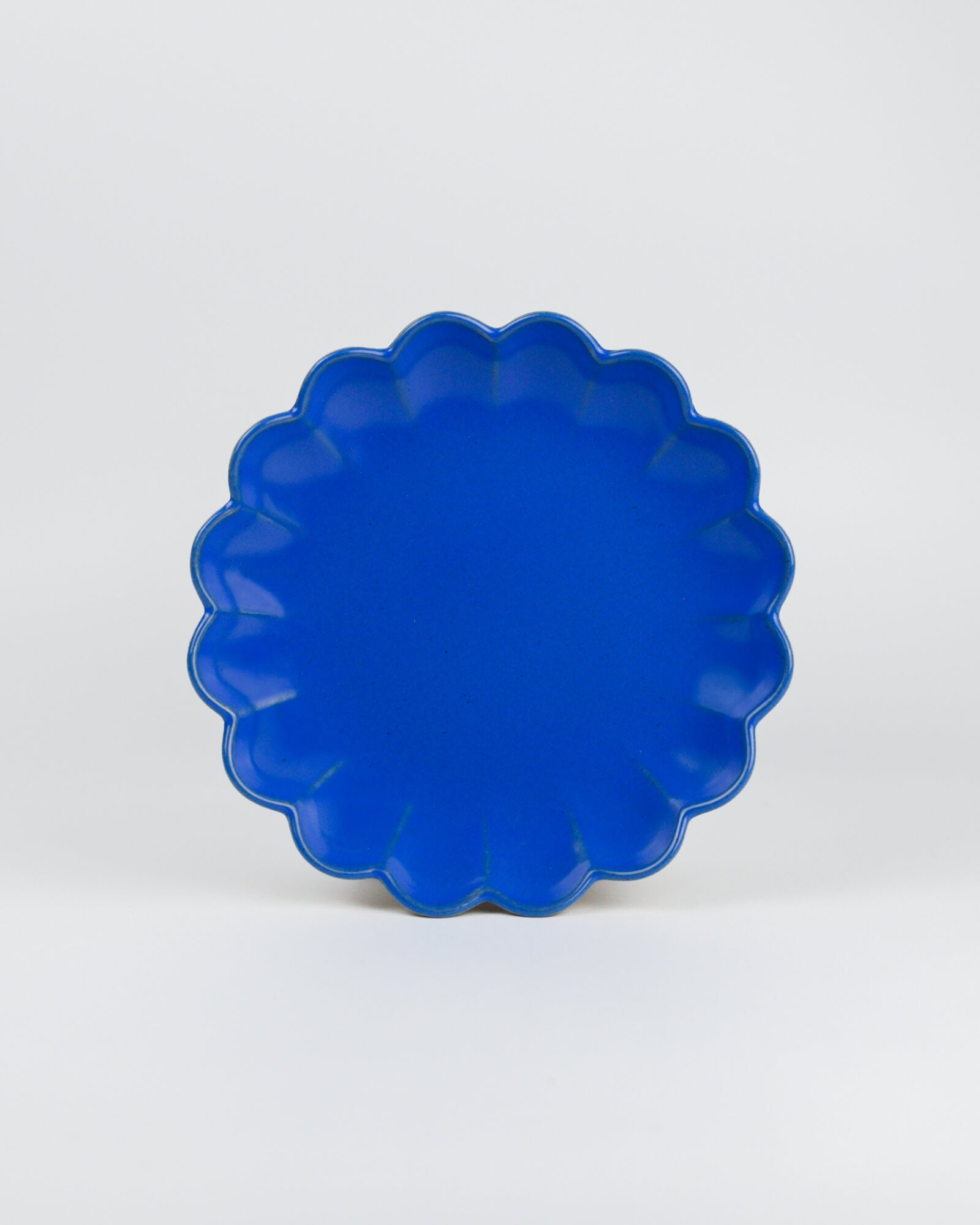 Blue scalloped-edge dish on a white background