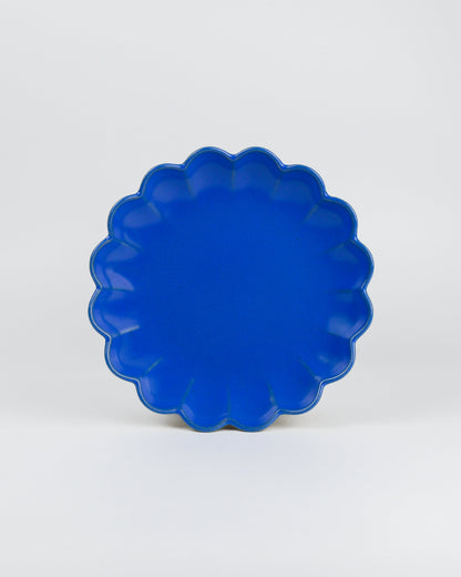 Blue scalloped-edge dish on a white background