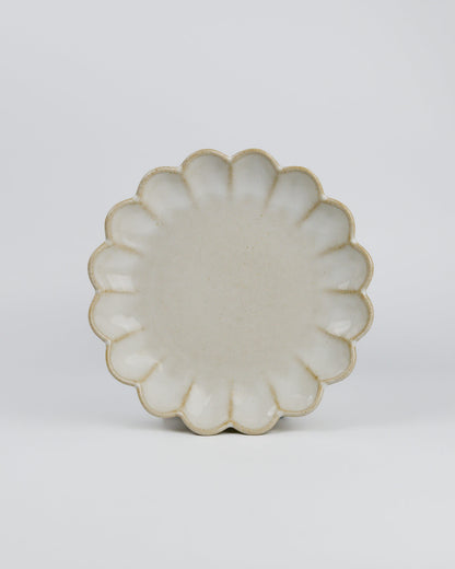 Decorative ceramic plate with a scalloped edge on a white background