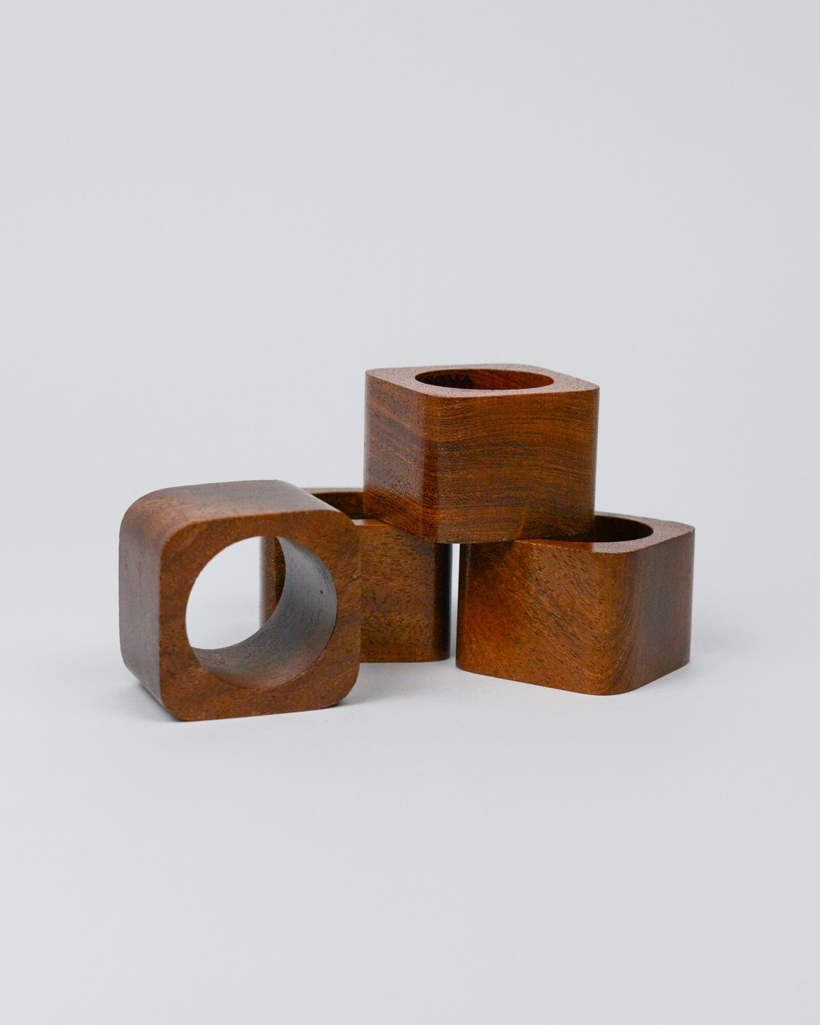 Set of 4 light wooden squared napkin rings on a white background