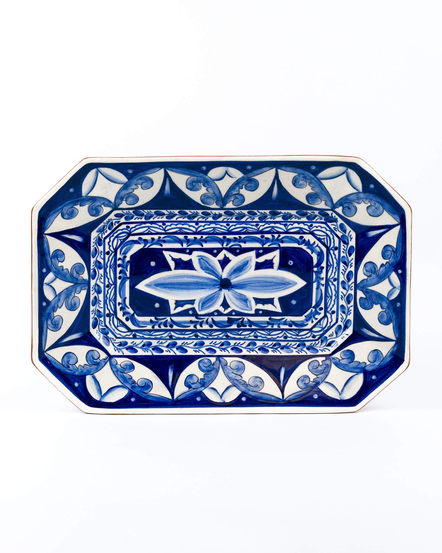 Decorative blue and white ceramic terracotta platter with intricate patterns on a white background