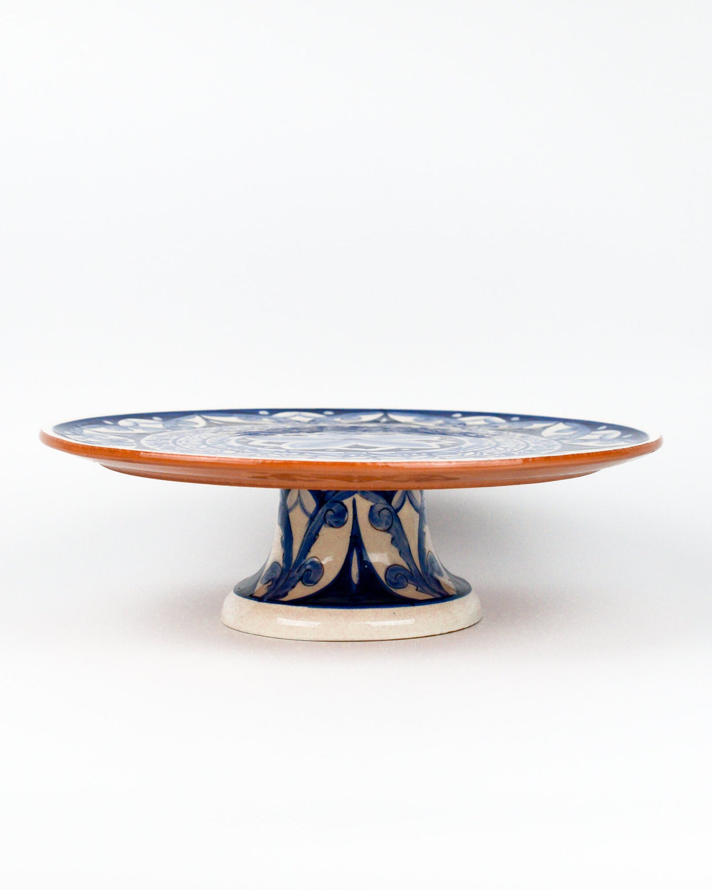 Ceramic terracotta cake stand with blue floral design on a white background