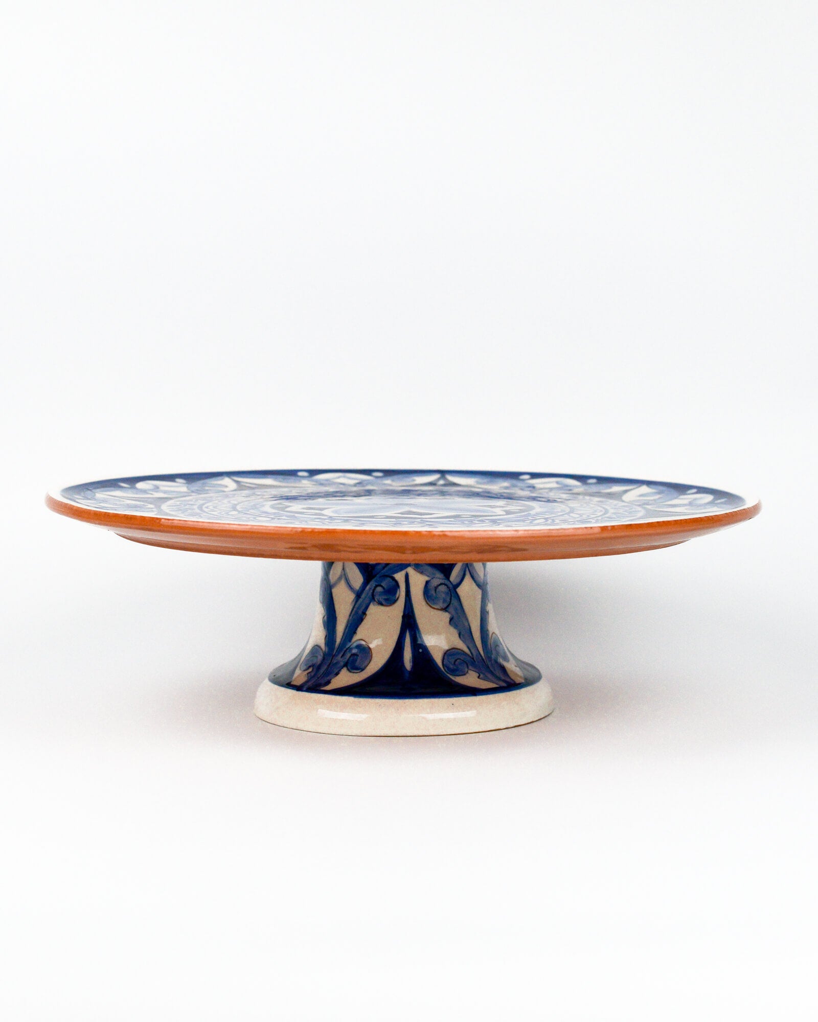 Ceramic terracotta cake stand with blue floral design on a white background