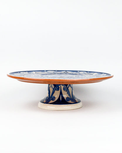 Ceramic terracotta cake stand with blue floral design on a white background