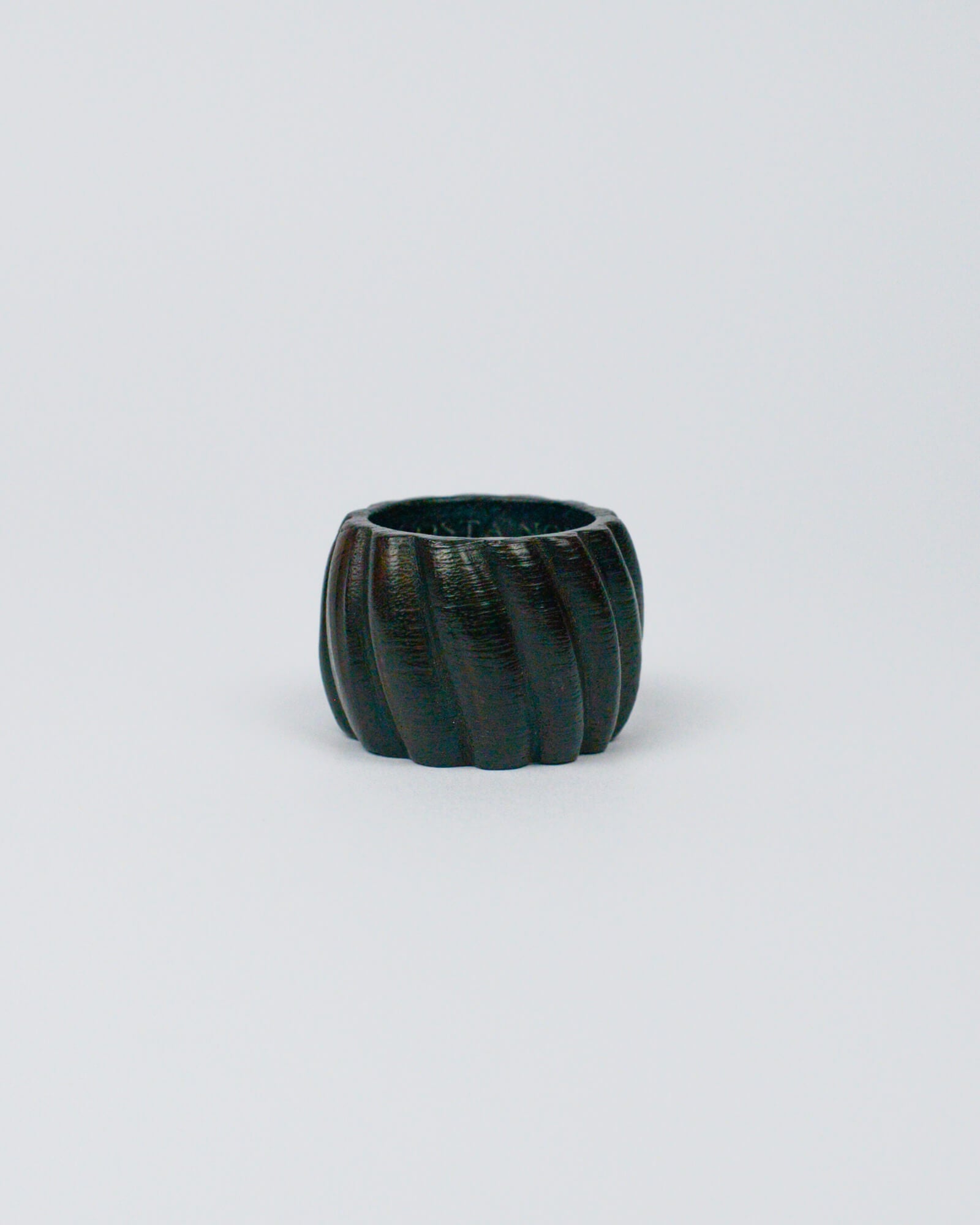 Dark wooden ribbed napkin ring on a white background