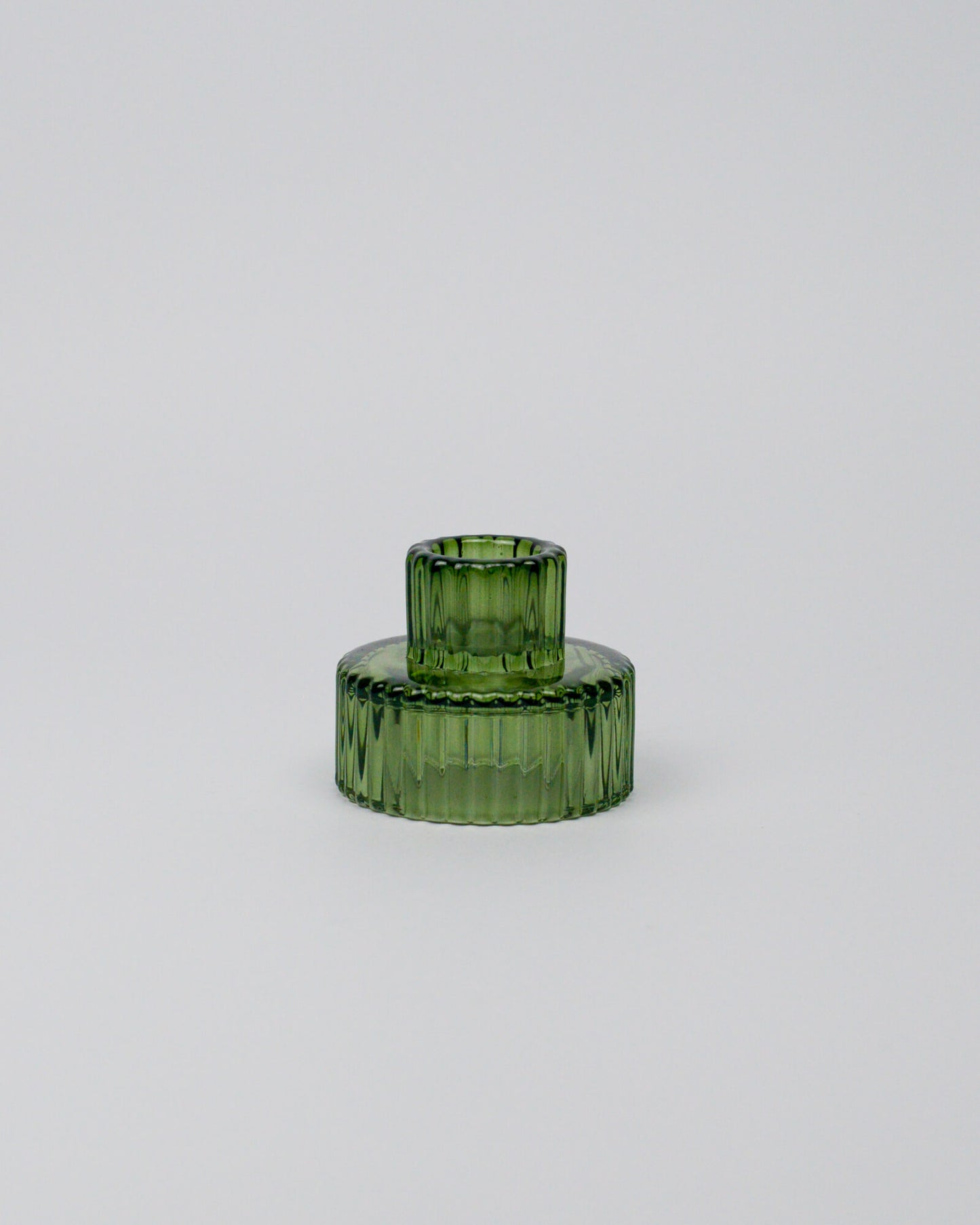 Green glass candle holder on a white background