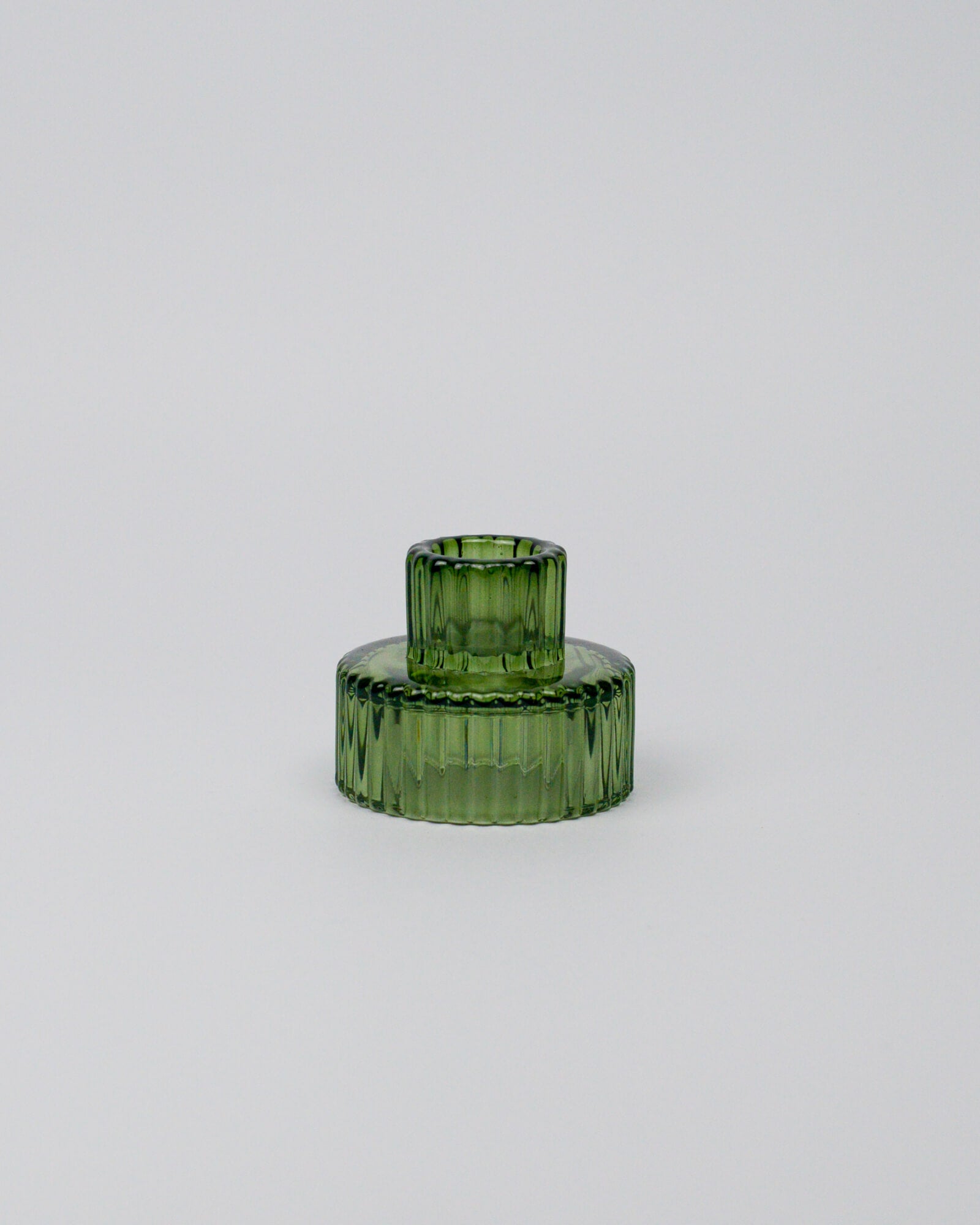Green glass candle holder on a white background
