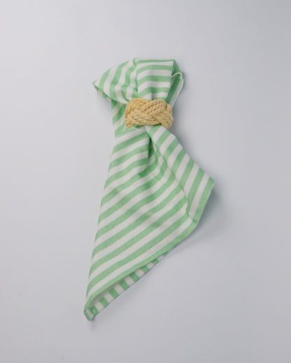 Green and white striped cotton and linen blend cloth napkin with a rope napkin ring on a white background