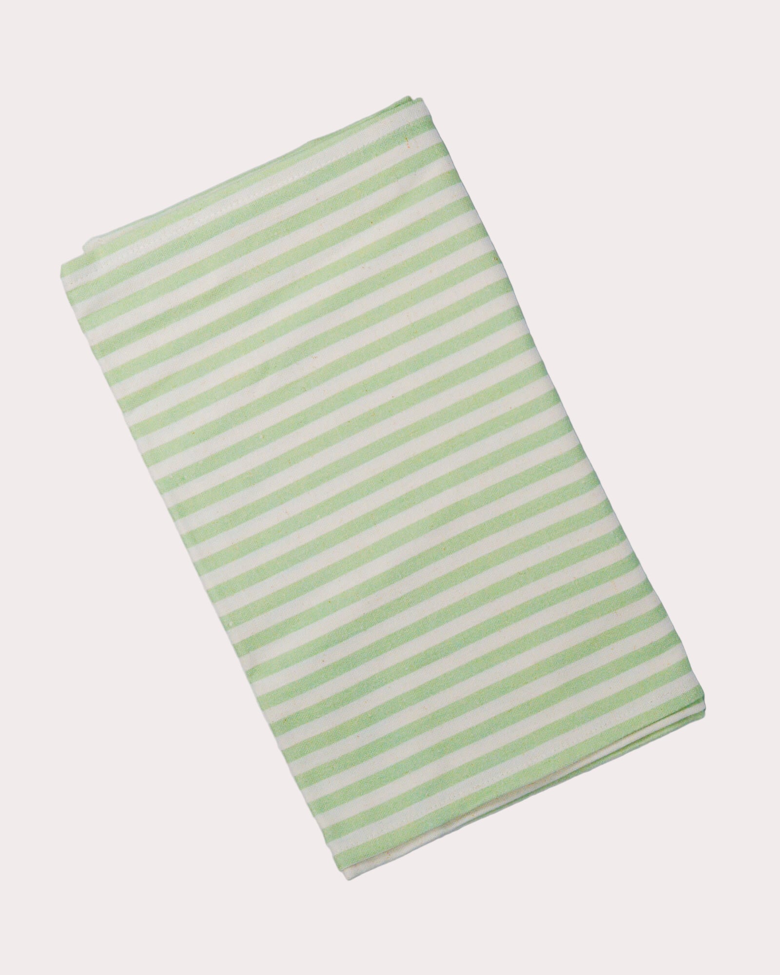 Cotton and linen blend table runner with green and white stripes on a white background