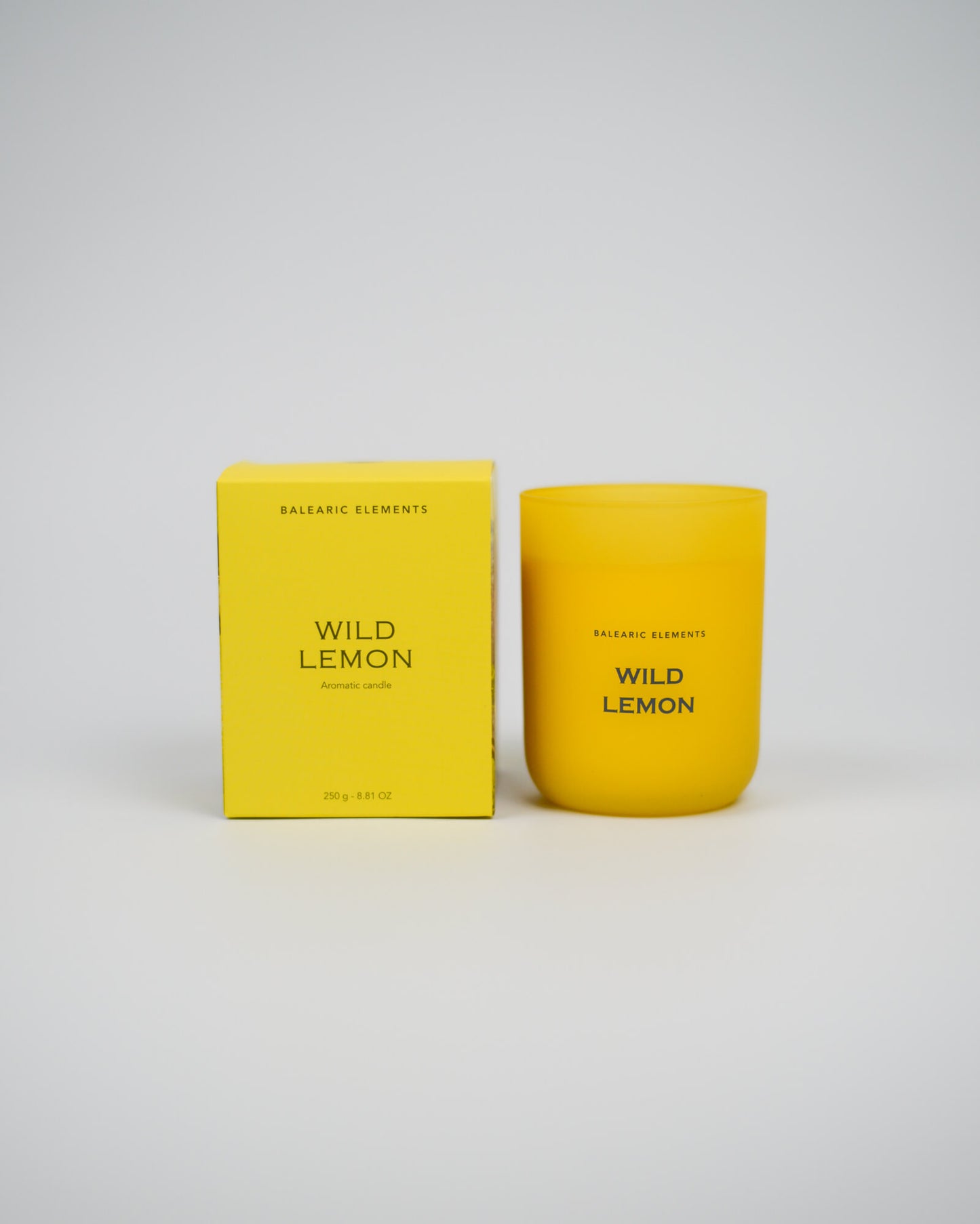 Yellow scented candle and packaging with 'Wild Lemon' text on a white background