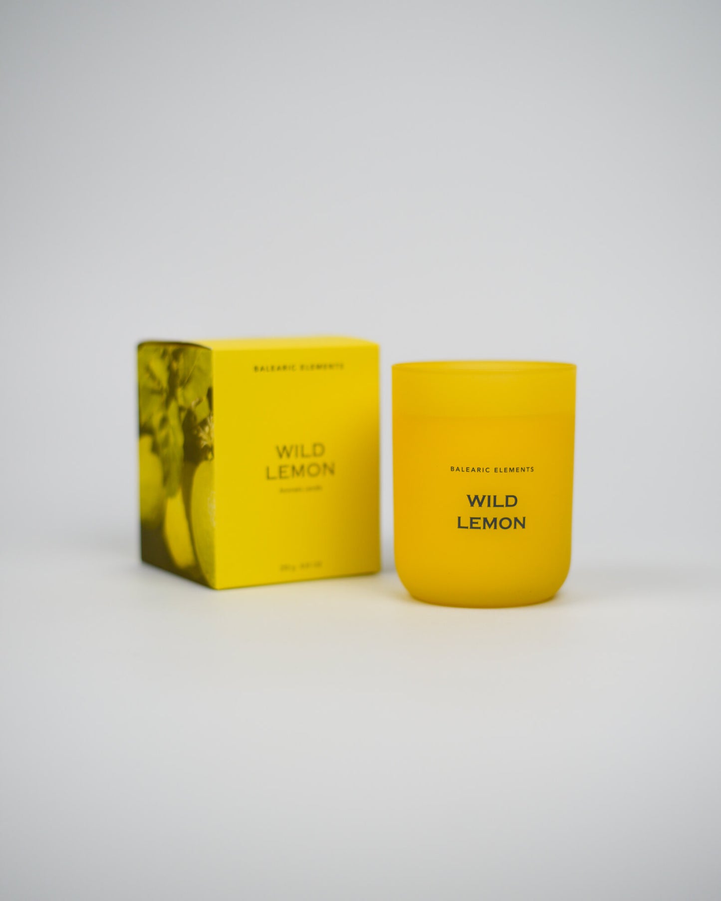 Yellow candle and packaging labeled 'Wild Lemon' on a white background